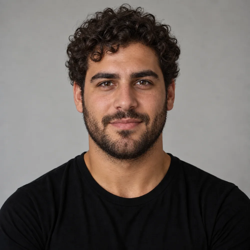 Elias before, with natural dark brown curls and a short beard