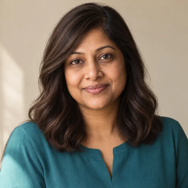 A woman in her forties with long, straight black hair, wearing a natural-looking wig