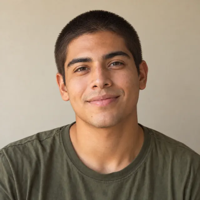 A man in his twenties with chin-length wavy hair, with a buzz cut