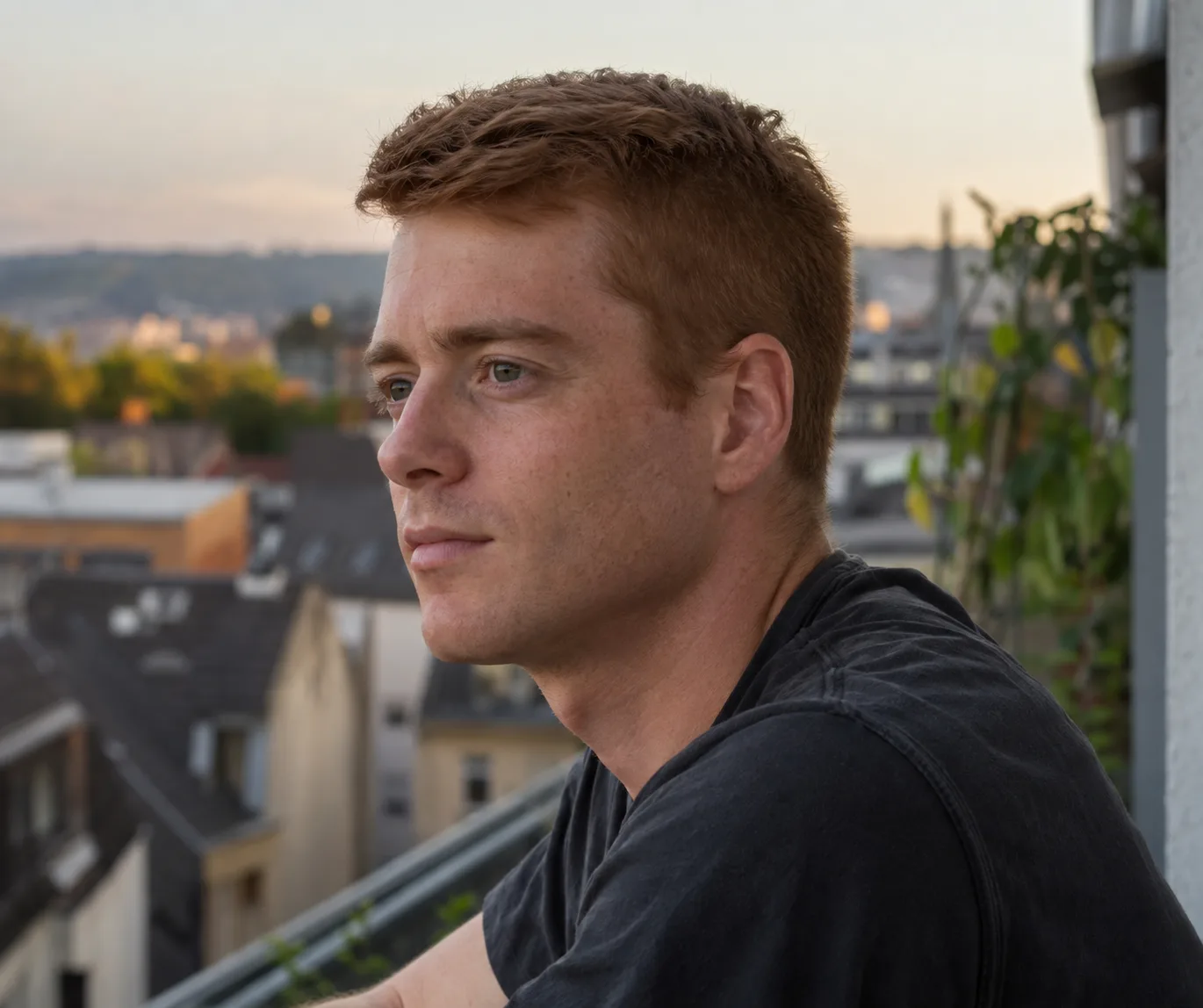 Ginger haired man on a balcony with a high and tight three weeks grown out, the sides filled in and the line between sides and top gone