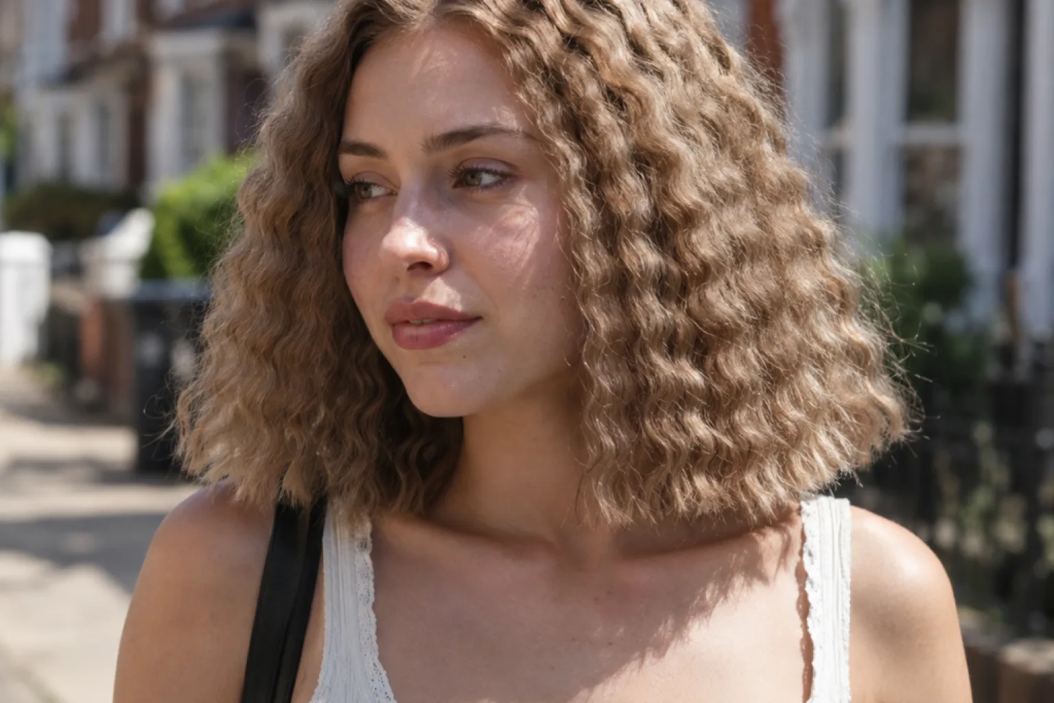 Sandy blonde collarbone bob crimped into a wide triangular silhouette on a sunny street